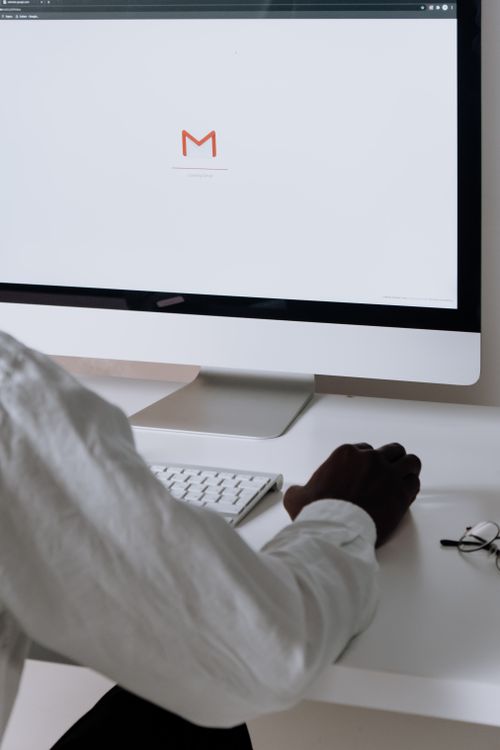 Professional reviewing email at a desktop computer