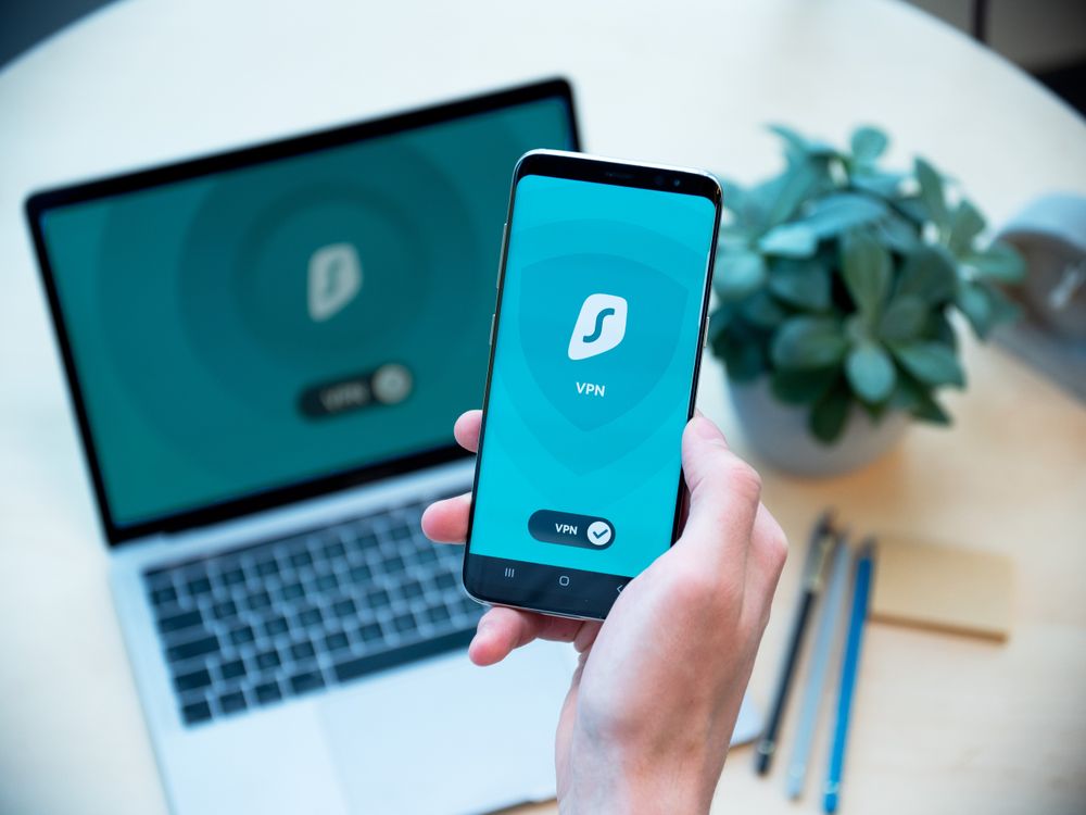VPN security app active on a mobile phone beside a laptop