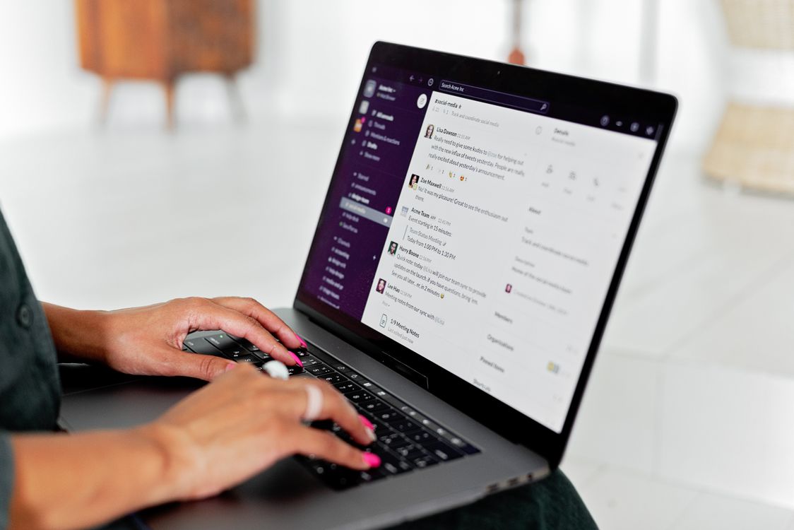 Woman at a desk working on a laptop and smartphone